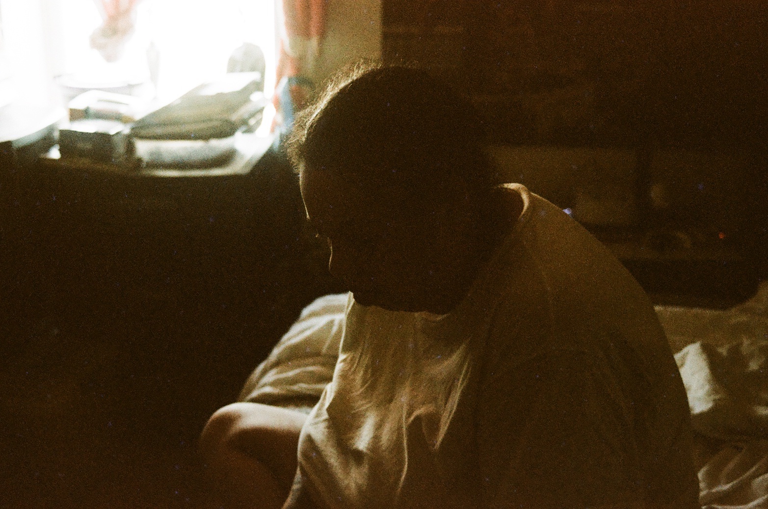 A grainy low-light portrait in a quiet room