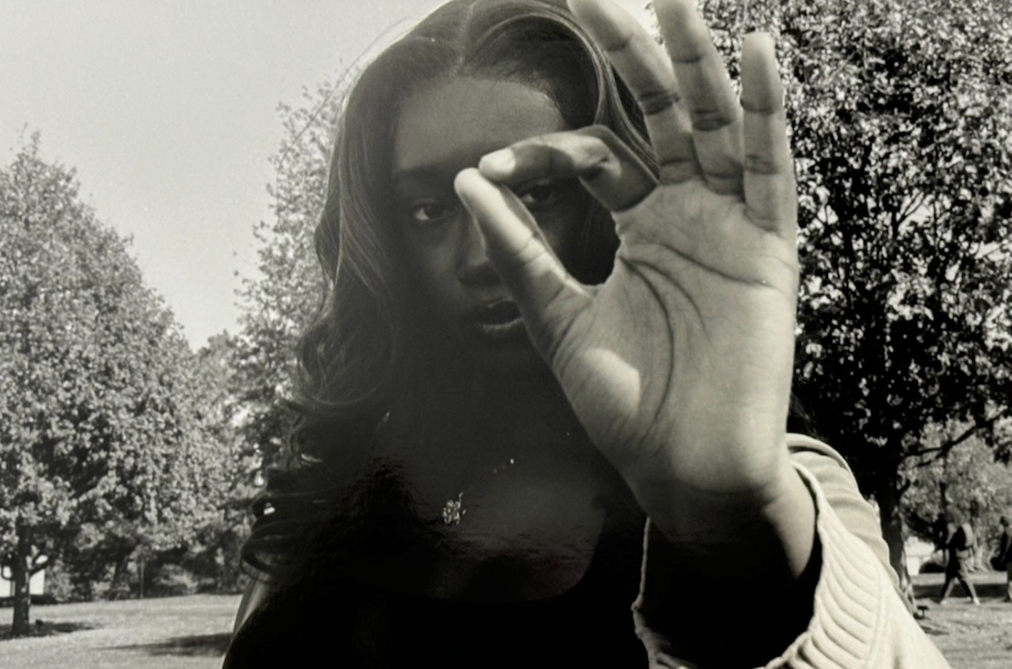 A woman looking through the circle formed by her hand